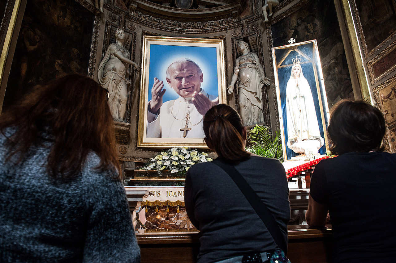 People kneel in front of a painting depincting John Paul II, Roma, Italy ©Alessia GIULIANI/CPP